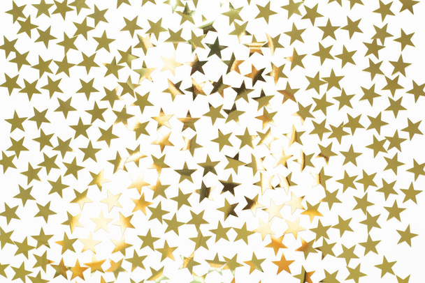 Fondo navideño con confeti estrella dorada. Fondo de vacaciones para Año Nuevo sobre fondo blanco - Foto, Imagen