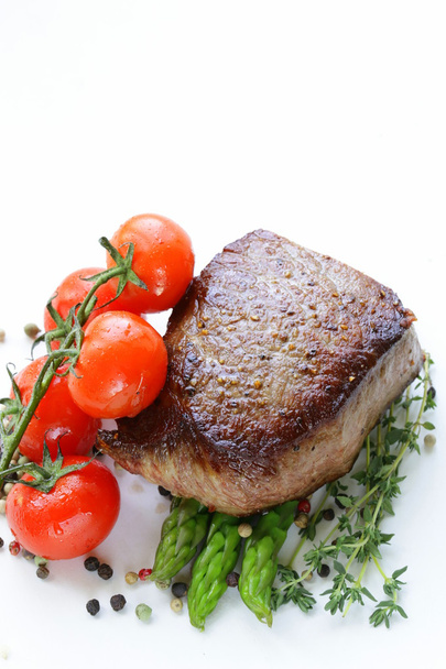 Стейк з м'яса на грилі з овочевим гарніром (аспарагус та помідори
) - Фото, зображення