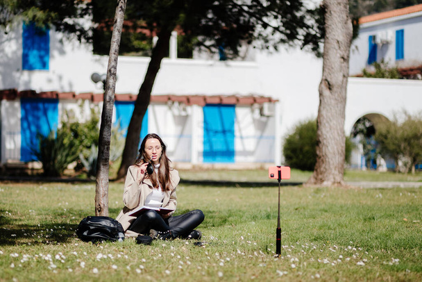 jonge vrouw online leren op mobiel internet buiten - Foto, afbeelding