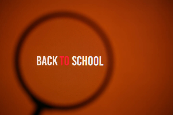 Inscription zpět do školy na červeném monitoru přes lupu - Fotografie, Obrázek