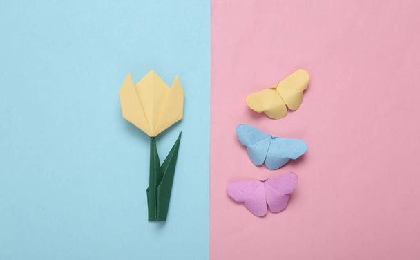 Lente of zomer compositie van origami tulpen en vlinders op roze blauwe achtergrond - Foto, afbeelding