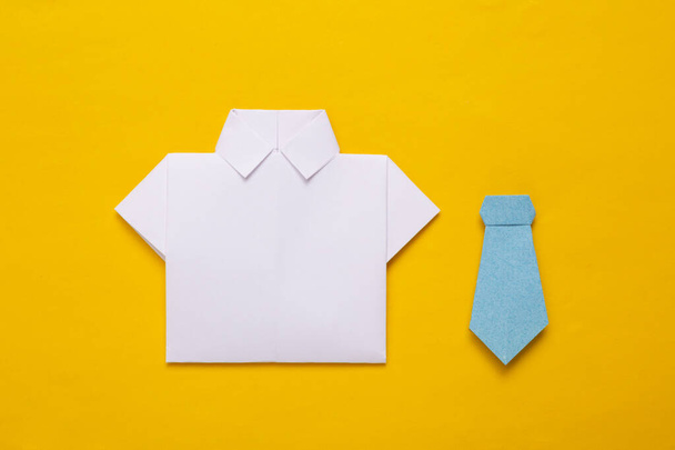 Белая бумажная рубашка оригами и галстук-бабочка на желтом фоне - Фото, изображение