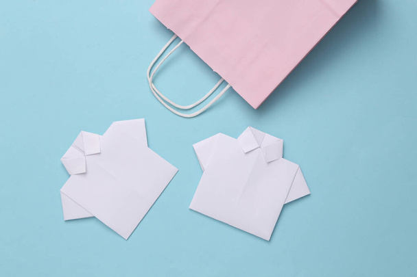 Nákupní taška s origami košile na modrém pozadí. Nákupní koncept - Fotografie, Obrázek