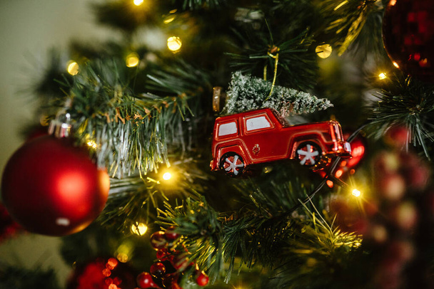 De rode auto op de kerstboom is een groot plan.. - Foto, afbeelding