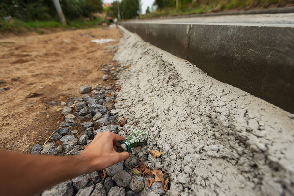 Сломанный бордюр вдоль дороги. ремонт тротуара. цементные плиты в трещинах и некачественных материалах. коррупция дорожных рабочих - Фото, изображение