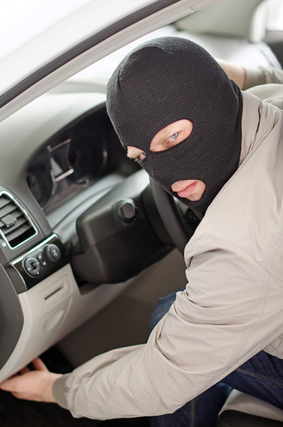 Thief in mask steals expensive new car. - Foto, Imagem