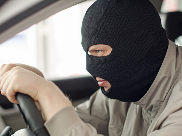 Thief in mask steals expensive new car. - Fotó, kép