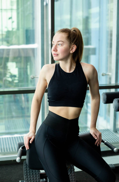 Young attractive girl in sportswear in a fitness club. Sports concept - Photo, Image