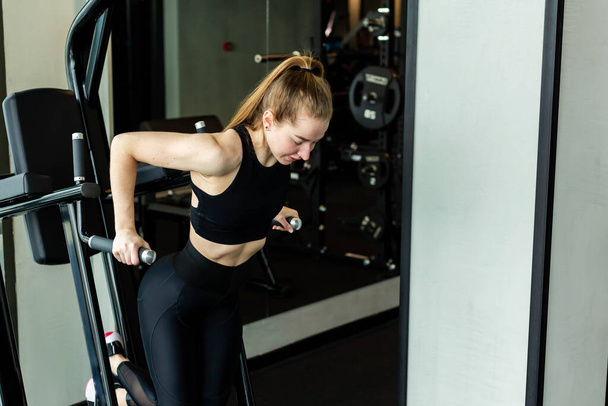 Young attractive girl in sportswear in a fitness club. Sports concept - 写真・画像