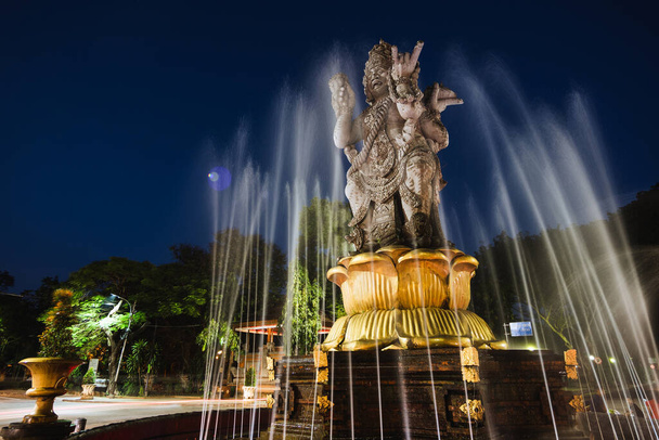 インドネシア・バリの首都デンパサール市中心部にあるヒンドゥ教の神ブラフマを描いたパトゥン・カトル・ムカ像の夜景. - 写真・画像