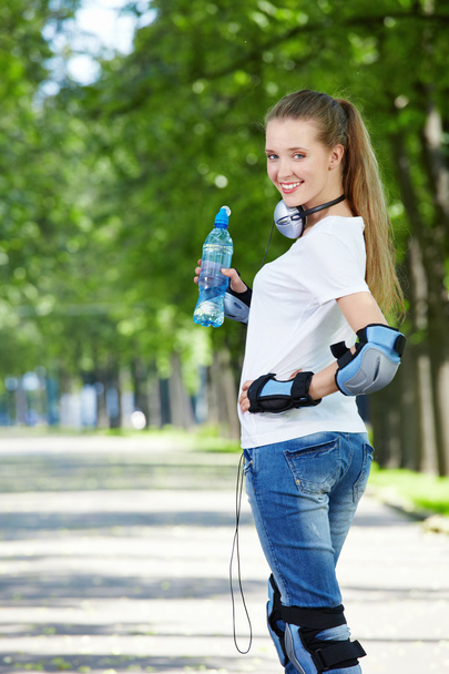 The young attractive girl in equipment with a water bottle - Foto, afbeelding