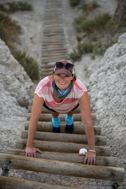 Щаслива жінка піднімається колодою Сходи вгору крутий схил
 - Фото, зображення