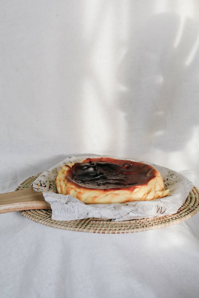 Torta di formaggio basco bruciato con crema di formaggio zuccherato e uova e panna cotta in una crosta di briciole. Un vassoio di cheesecake fatto in casa sul tavolo - Foto, immagini