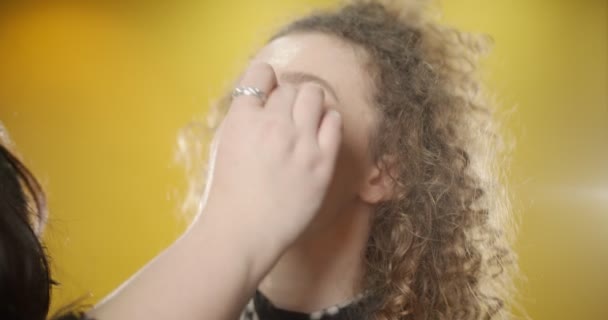 Maquillaje de aplicación a una chica en el estudio - Imágenes, Vídeo