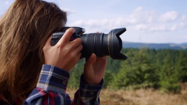 Φωτογράφος φωτογραφίζει το τοπίο. Γυναίκα που χρησιμοποιεί φωτογραφική μηχανή στα βουνά - Πλάνα, βίντεο