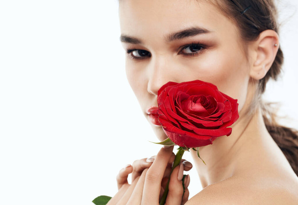 Side view of romantic woman with red flower near face - Фото, изображение