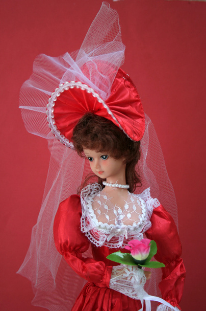 Изящный взгляд куклы в красном свадебном наряде
 - Фото, изображение