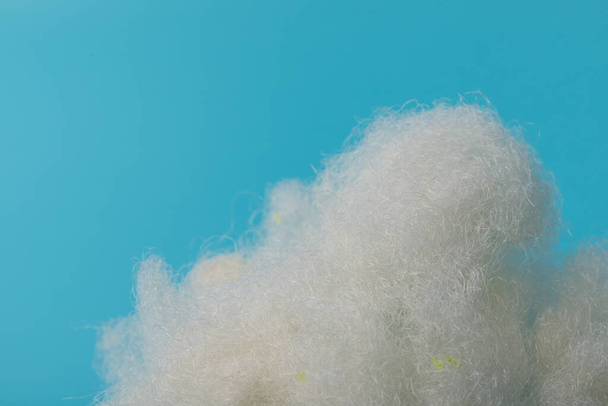 Λευκό Σιδηρούν Αέρα. Τύπος Μαξιλάρι Υλικό. Sintepon Filler σε μπλε φόντο, απαλή υφή - Φωτογραφία, εικόνα