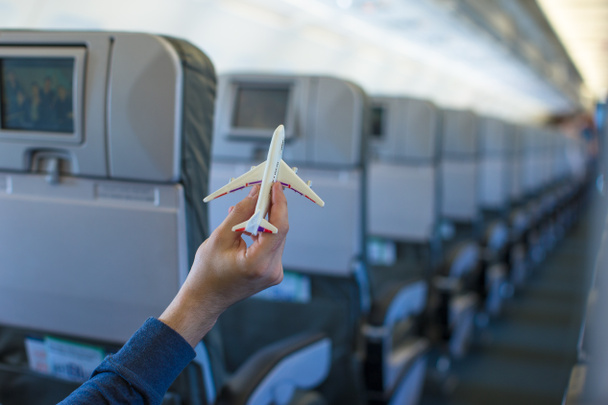 大型航空機の中の飛行機モデルを持っている手を閉じる - 写真・画像