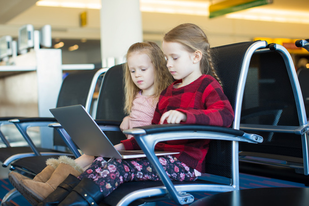 Crianças com um laptop no aeroporto enquanto espera seu voo
 - Foto, Imagem