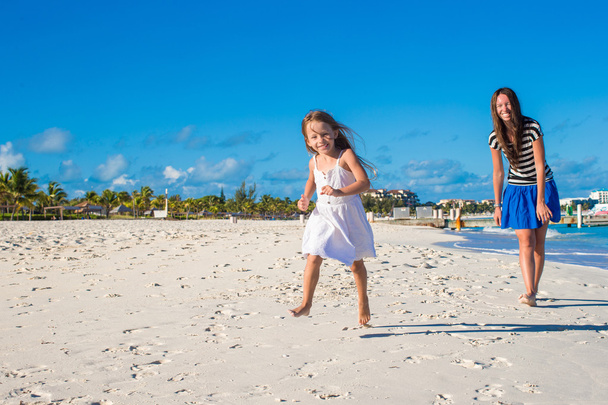 Madre y su hijita se divierten en la playa exótica en un día soleado
 - Foto, Imagen