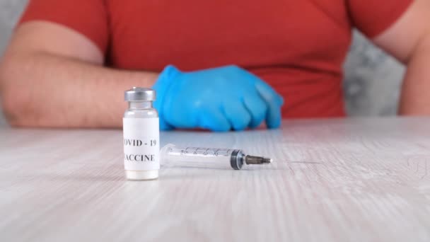 Flacons met een vaccin tegen coronavirus, influenza en gevaarlijke ziekten en een spuit en mannelijke handen. Corona virus, griep, injecties, injecties en klinische proeven behandelingsconcept tijdens pandemie - Video