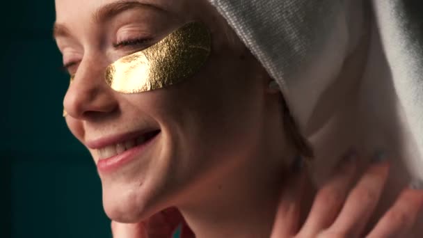 Веснушчатая женщина с рыжими волосами улыбается в золотых повязках на глазах - Кадры, видео