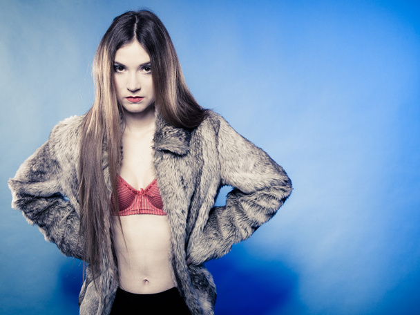 Sexy girl with long hair in red bra underwear and fur coat on blue - Foto, immagini