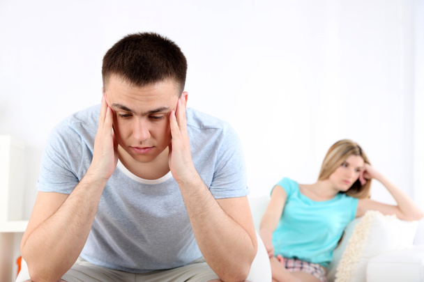 Portrait of young man and woman  conflict sitting on sofa argue unhappy, on home interior background - Photo, Image
