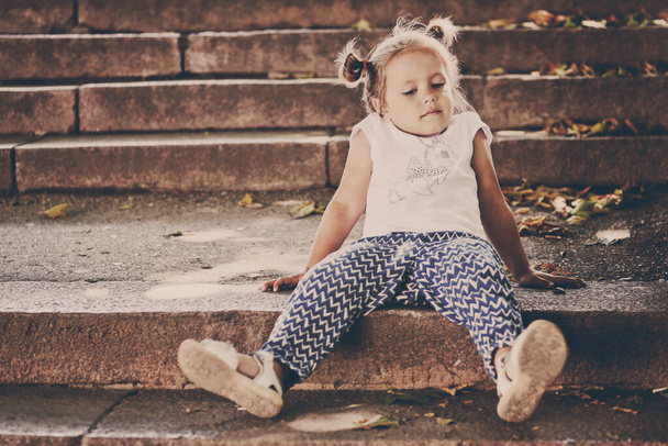 funny toddler girl sitting on the stairs - Zdjęcie, obraz
