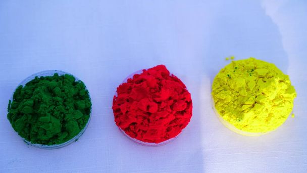 Makro záběr červené, zelené a žluté Gulal, mělké hloubky ohniska. Natural Edible Pigment Red Holi Gulal detailní záběr. - Fotografie, Obrázek