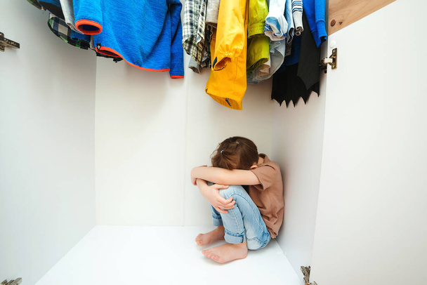 Smutný chlapec schovaný ve skříni. Domácí násilí a zneužívaný koncept. Nešťastné dětství. Rozrušený kluk brečí ve svém pokoji. - Fotografie, Obrázek