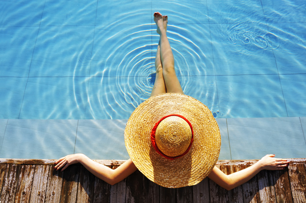 Şapkalı kadın havuzda dinleniyor. - Fotoğraf, Görsel