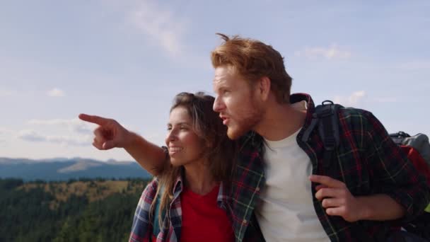 Женщина и мужчина стоят на вершине горы. Мужчина-турист, указывающий пальцем - Кадры, видео