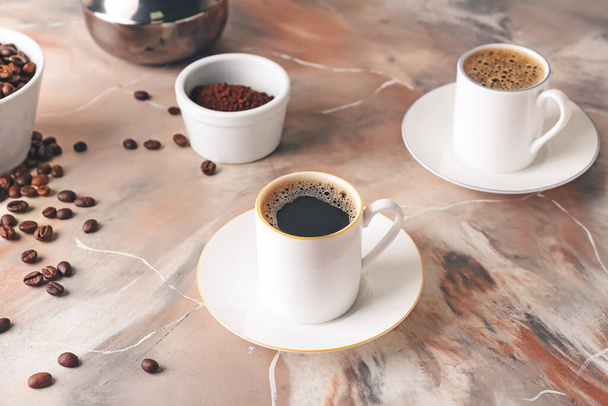 Tassen mit leckerem heißen Kaffee auf Grunge-Hintergrund - Foto, Bild