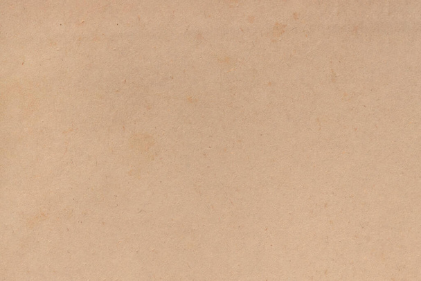 Die Oberfläche alter, abgenutzter brauner Pappe, mit Falten und Flecken überzogen. Gleichmäßige leichte abstrakte Textur. - Foto, Bild