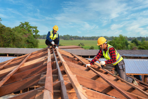 Toiture, Deux travailleurs couvreur constructeur travaillant sur la structure du toit sur le chantier de construction, concept de construction de travail d'équipe. - Photo, image