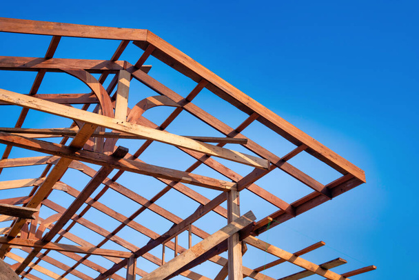 Cadre de toit en bois d'une maison contre un ciel bleu. Le cadre du chalet. Le début de la construction de la maison, chantier de construction. - Photo, image