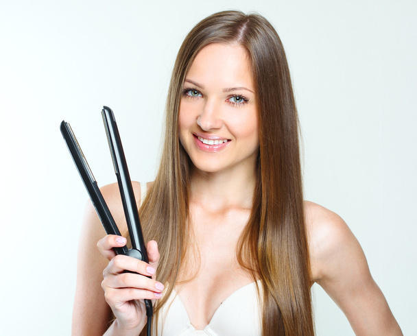 Beautiful woman styling her long hair - Foto, Imagen