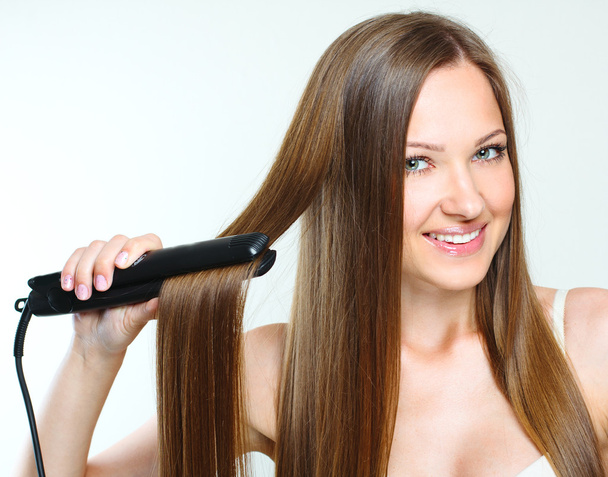 Beautiful woman styling her long hair - Zdjęcie, obraz