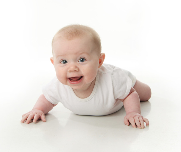 Retrato de um bebê bonito vestindo uma camisa de macacão deitado na barriga, no branco
 - Foto, Imagem