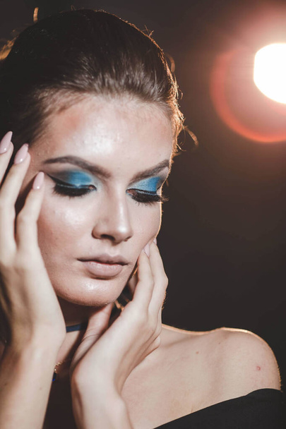 An attractive Bosnian Caucasian woman with blue eye makeup against a bright light background - Foto, imagen