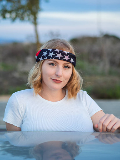 A portrait of a beautiful Caucasian woman with a nose ring and a trendy bandana  at a park - Photo, Image