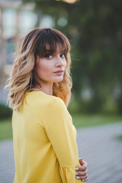 A vertical portrait of an attractive young female with beautiful makeup and a yellow shirt - Foto, Imagen