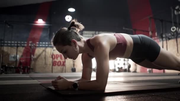 Fiatal nő csinál planking gyakorlat tornaterem - Felvétel, videó