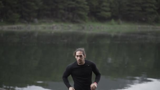 Sportsman training by lake in woods - Footage, Video