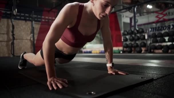 Jovem do sexo feminino fazendo exercício de prancha no ginásio - Filmagem, Vídeo