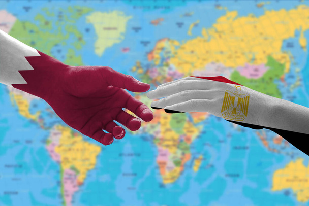 Mani dipinte bandiere di Egitto e Qatar. Il concetto di relazioni tra i due paesi - Foto, immagini