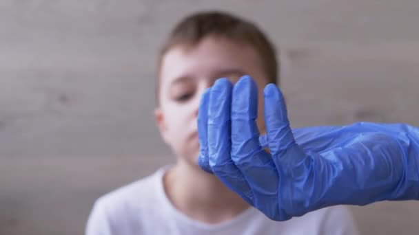Lääkäri, lastenlääkäri lateksinitriilikäsineet, antaa lapselle kaksi pilleriä. 4K - Materiaali, video