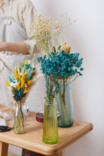 Armfuls de flores secas em pé em um vaso. Lindas flores secas de tons delicados. Materiais para uma oficina de fabricação de buquês - Foto, Imagem